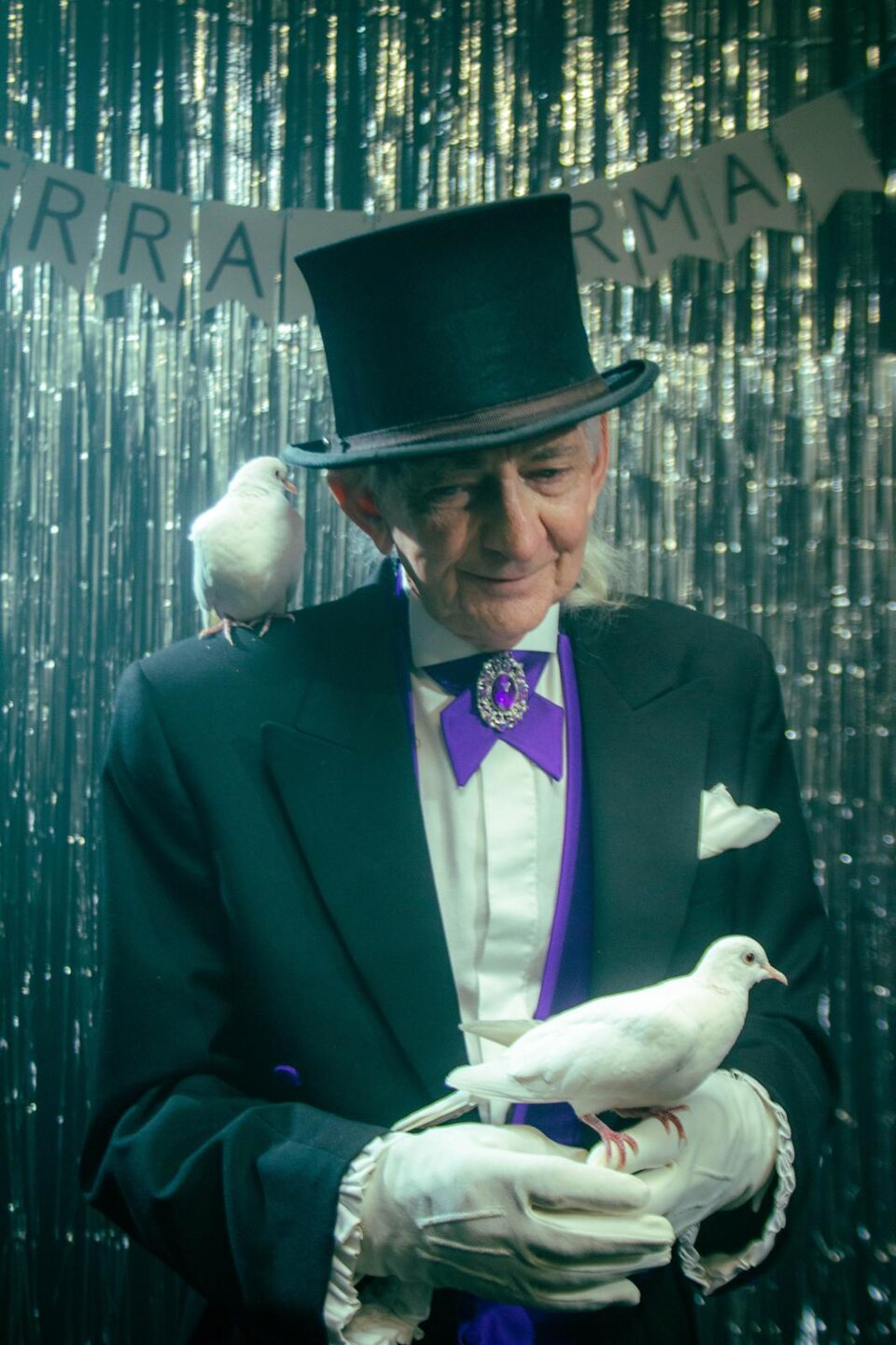 Pat Fallon in formal attire with white doves during a wedding performance moment.